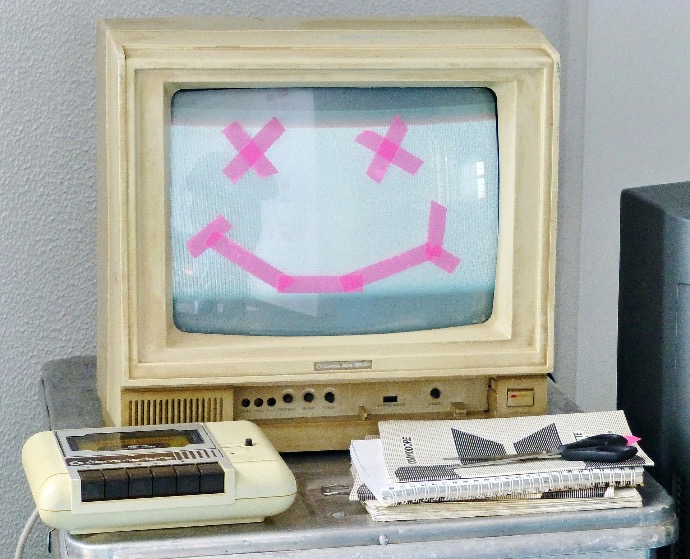 white crt tv turned on beside white remote control